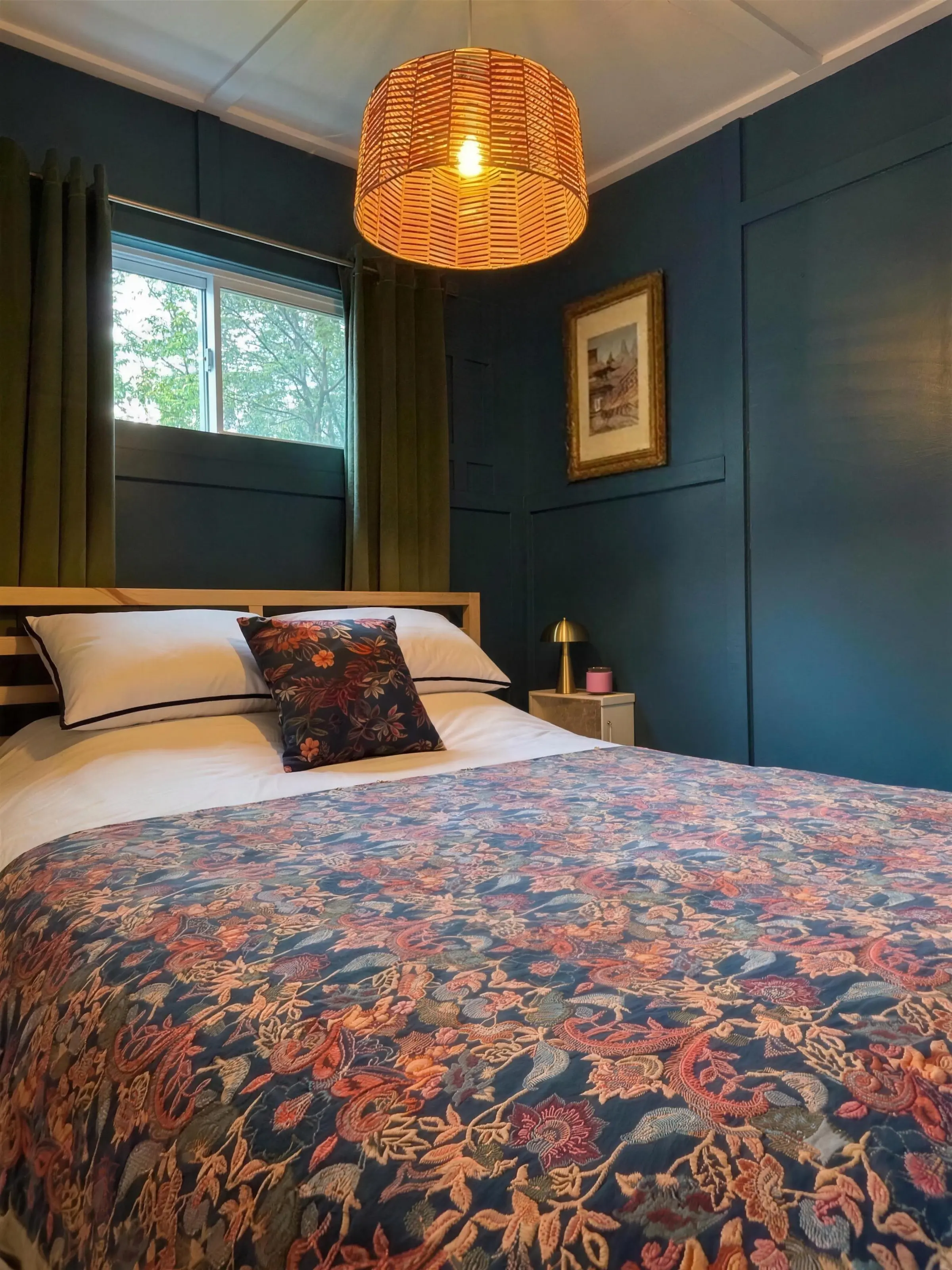 La chambre aux murs bleus du chalet Encore un peu..., sa suspension d’osier allumée au-dessus du lit queen