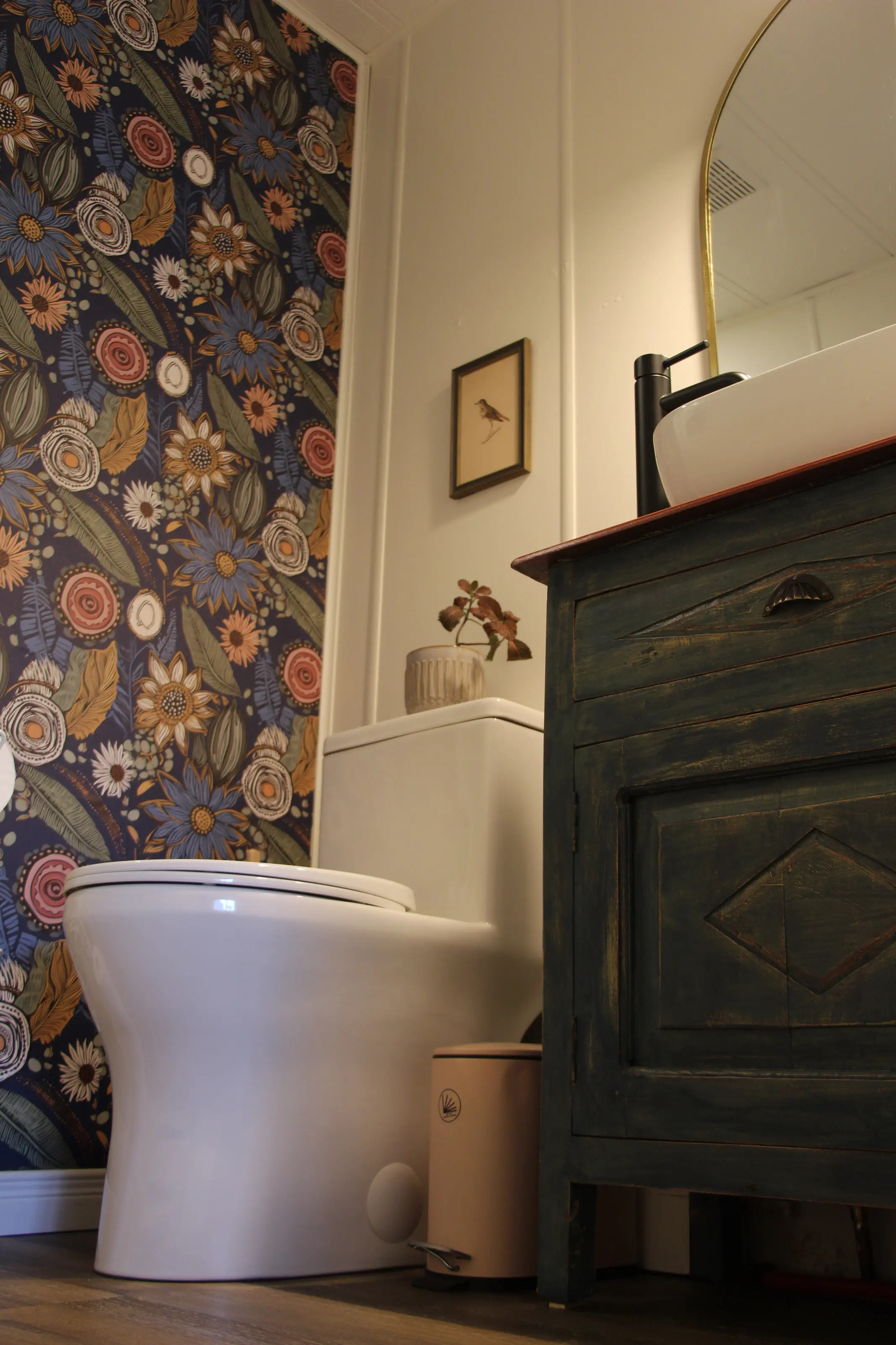 La salle de bain, papier peint fleuri et meuble-lavabo patiné